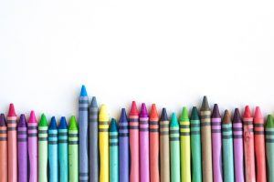 Crayons and pastels lined up isolated on white background for banner
